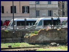 Modern trams at Largo di Torre Argentina. They are silver, green and red.